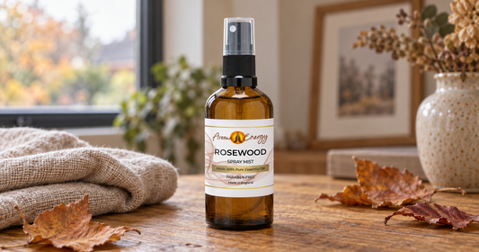 Aroma Energy Rosewood room spray on a table with a knitted throw and autumn leaves.